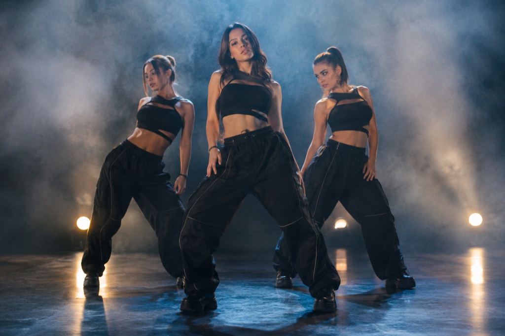 Side-by-side example: a single uploaded portrait on the left, the generated 720p 12-second vertical clip on the right, caught mid point choreography